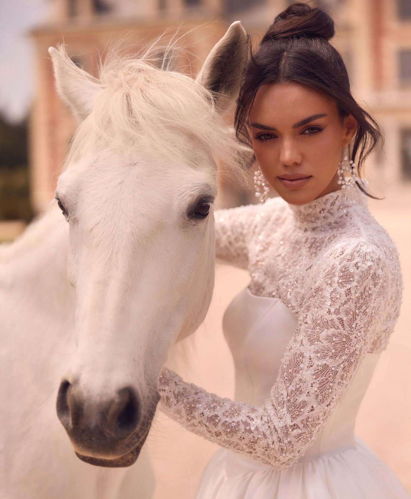 Braut mit elegantem Pferd vor einem Schloss, sie trägt ein perlenbesticktes Brautkleid BAO Warendorf, www.brautoutlet-warendorf.de Braut mit elegantem Pferd vor einem Schloss, sie trägt ein perlenbesticktes Brautkleid BAO Warendorf, www.brautoutlet-warendorf.de